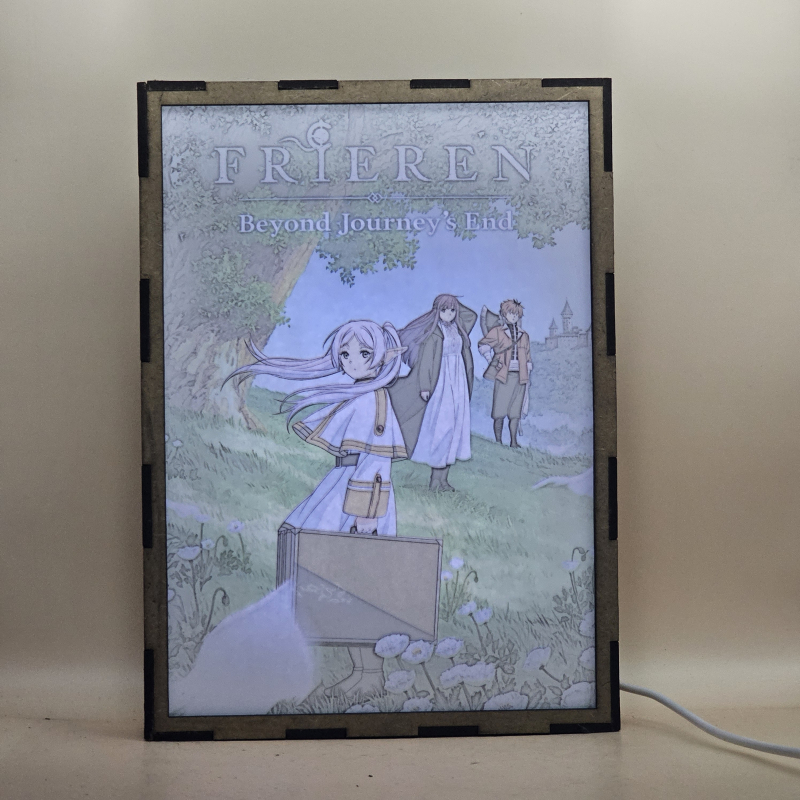 Lámpara ánime/manga  Frieren  con doble imagen del grupo Frieren, Fern y Stark, vista encendida, con luz ambiente, donde se revela la ilustración completa al encender la luz LED.