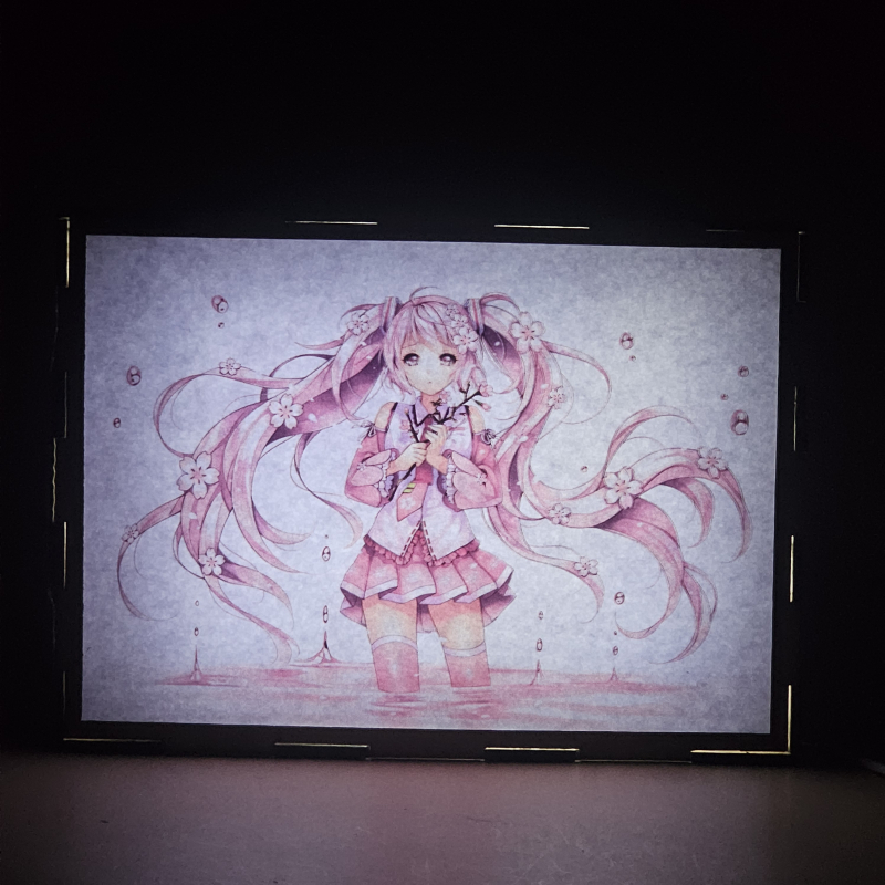 Lámpara ánime  Miku Hatsune  con doble imagen del personaje Miku Hatsune, vista encendida, donde se revela la ilustración completa al encender la luz LED.