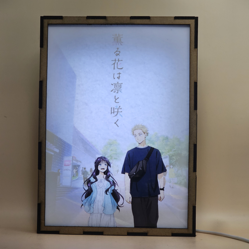 Lámpara ánime/manga  Kaoru Hana wa Rin to Saku  con doble imagen de la pareja Kaoruko Waguri y Rintaro Tsumugi, vista encendida, con luz ambiente, donde se revela la ilustración completa al encender la luz LED.