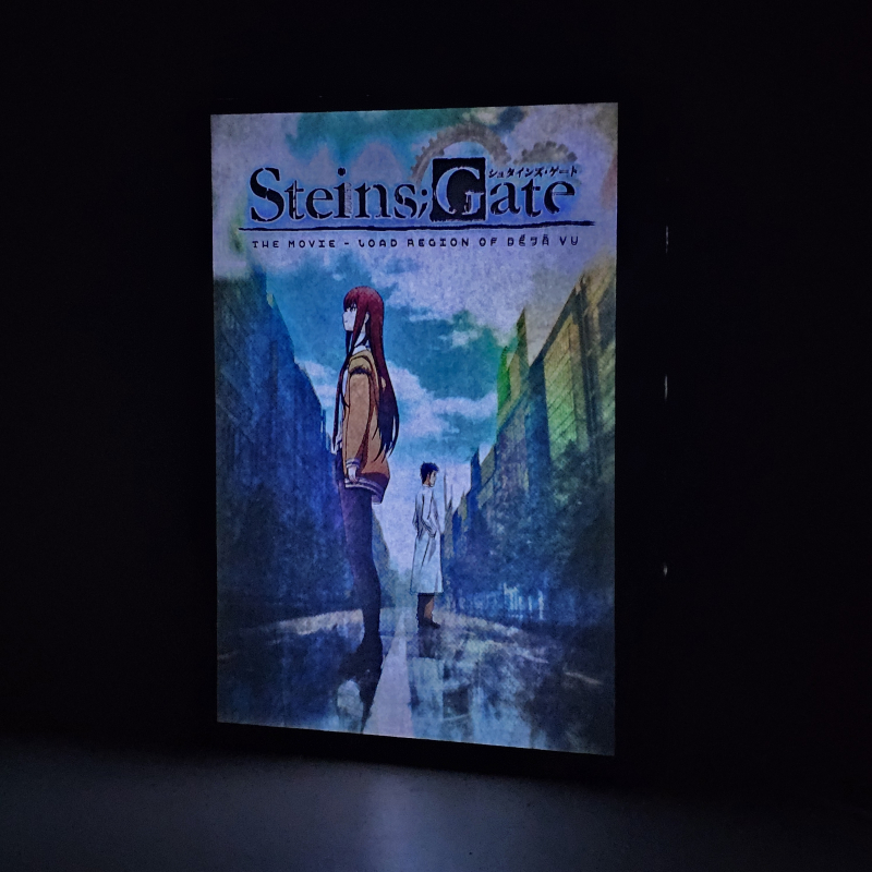 Lámpara ánime/manga  Steins;Gate  con doble imagen de la pareja Kurisu Makise y Rintaro Okabe, vista encendida, donde se revela la ilustración completa al encender la luz LED.