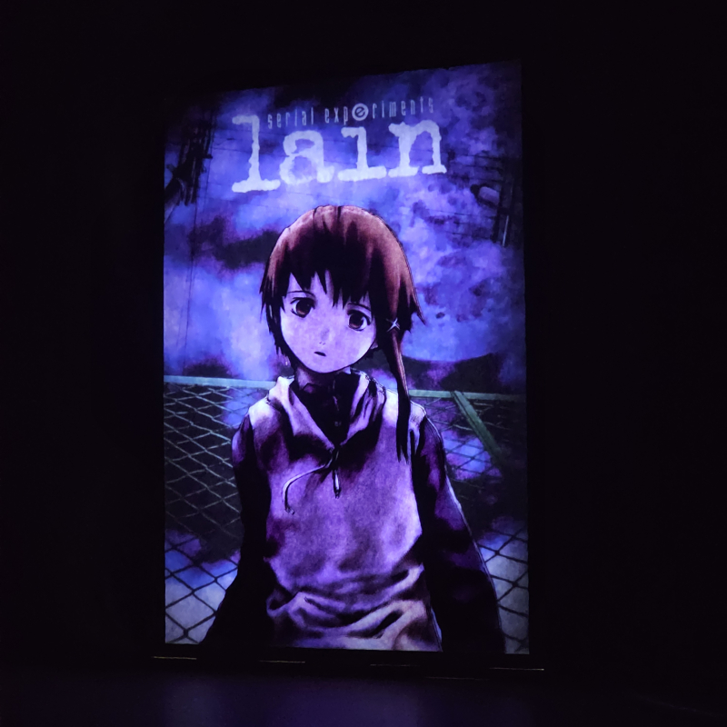 Lámpara ánime/manga  Serial experiments lain  con doble imagen del personaje Lain Iwakura, vista encendida, donde se revela la ilustración completa al encender la luz LED.