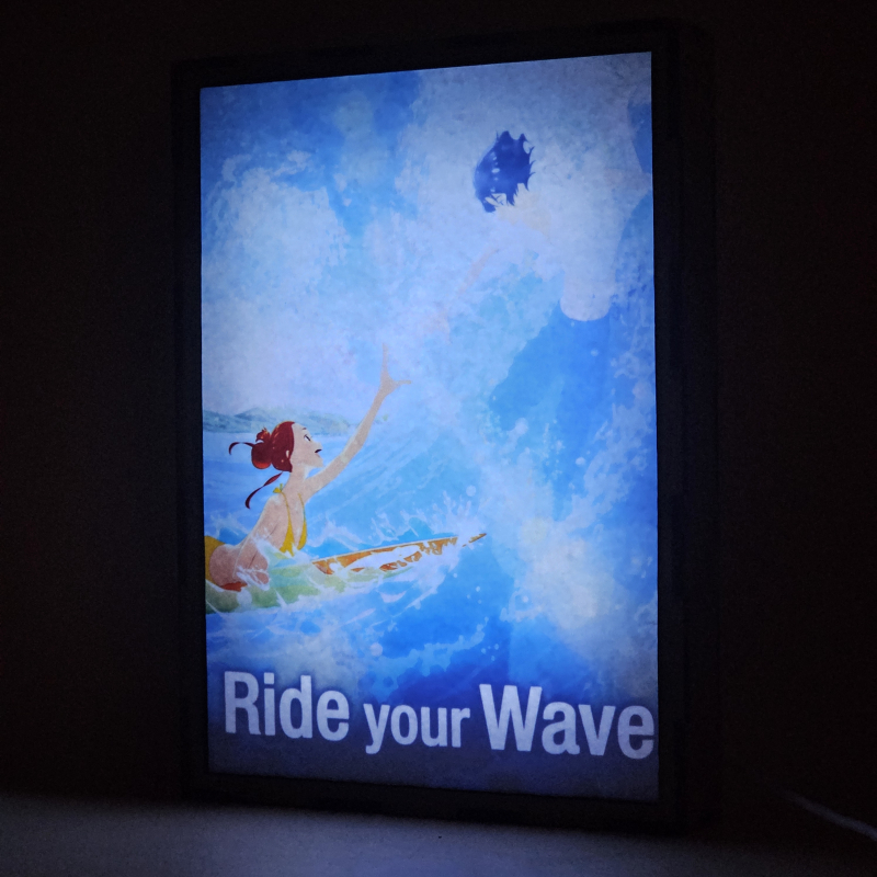 Lámpara LED Ride Your Wave con Hinako Mukaimizu surfeando y Minato Hinageshi entre las olas - encendida