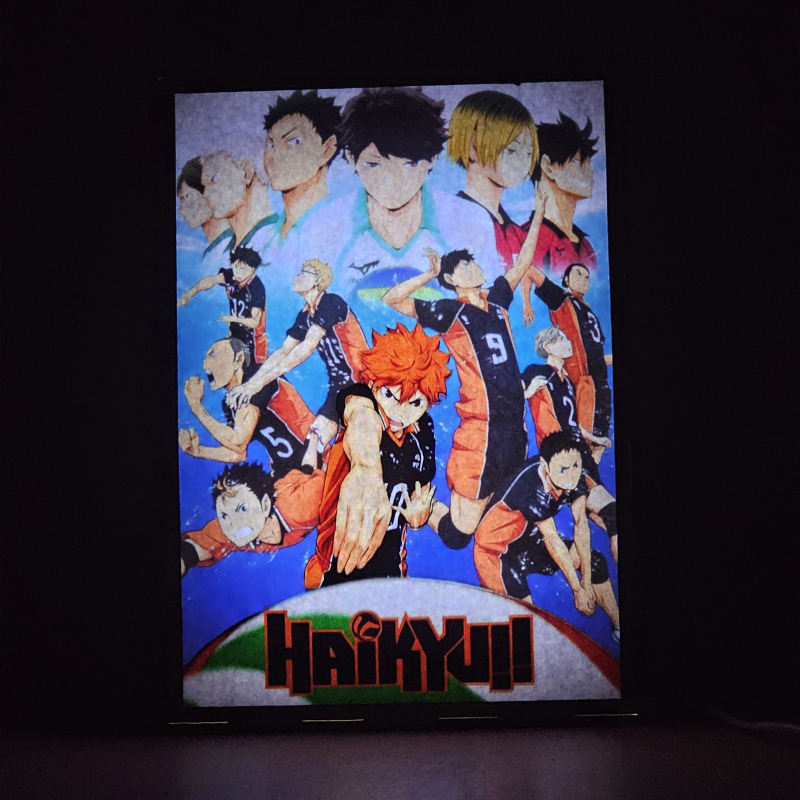 Lámpara ánime/manga  Haikyuu  con doble imagen del grupo Shoyo Hinata, Tobio Kageyama, Kei Tsukishima, Tadashi Yamaguchi, Kenma Kozume, Kuroo Tetsurō, Ryunosuke Tanaka, Yuu Nishinoya, Daichi Sawamura, Koushi Sugawara y Asahi Azumane, vista encendida, donde se revela la ilustración completa al encender la luz LED.