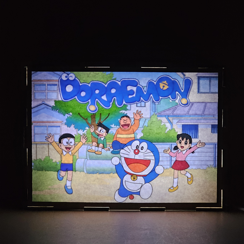 Lámpara ánime/manga  Doraemon, el gato cósmico  con doble imagen del grupo Doraemon, Nobita Nobi, Suneo Honekawa, Gigante y Shizuka Minamoto, vista encendida, donde se revela la ilustración completa al encender la luz LED.