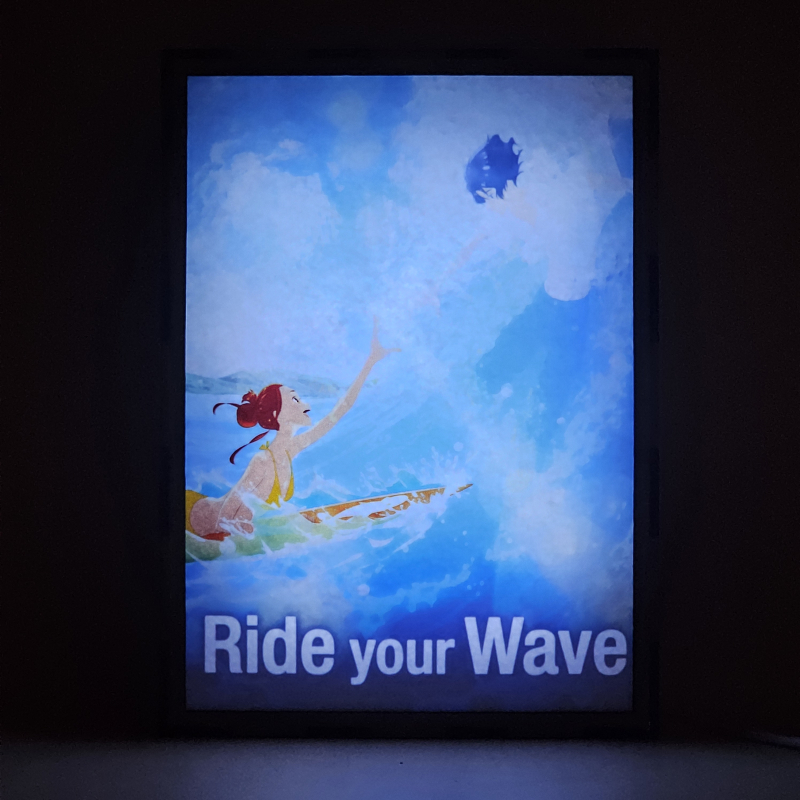 Lámpara LED Ride Your Wave con Hinako Mukaimizu surfeando y Minato Hinageshi entre las olas - encendida