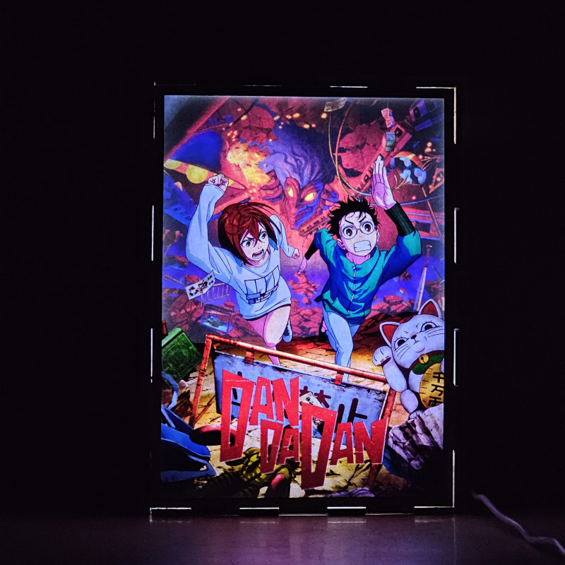 Lámpara ánime/manga  DAN DA DAN  con doble imagen de la pareja Okarun y Momo Ayase, vista encendida, donde se revela la ilustración completa al encender la luz LED.