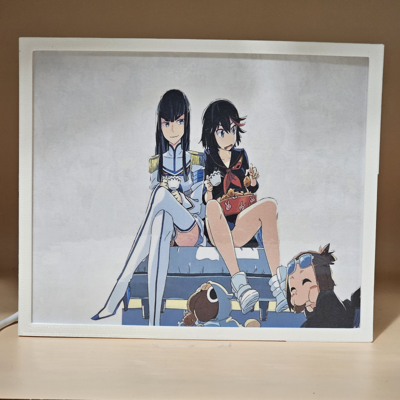 Lámpara ánime/manga  Kill la Kill  con doble imagen del grupo Ryuko Matoi, Satsuki Kiryūin, Mako Mankanshoku, Senketsu, Nonon Jakuzure, Ira Gamagōri, Mataro Mankanshoku, Houka Inumuta, Aikurō Mikisugi, Uzu Sanageyama, Tsumugu Kinagase, Barazo Mankanshoku y Mitsuzō Soroi, vista apagada, se esconde la imágen de atras.