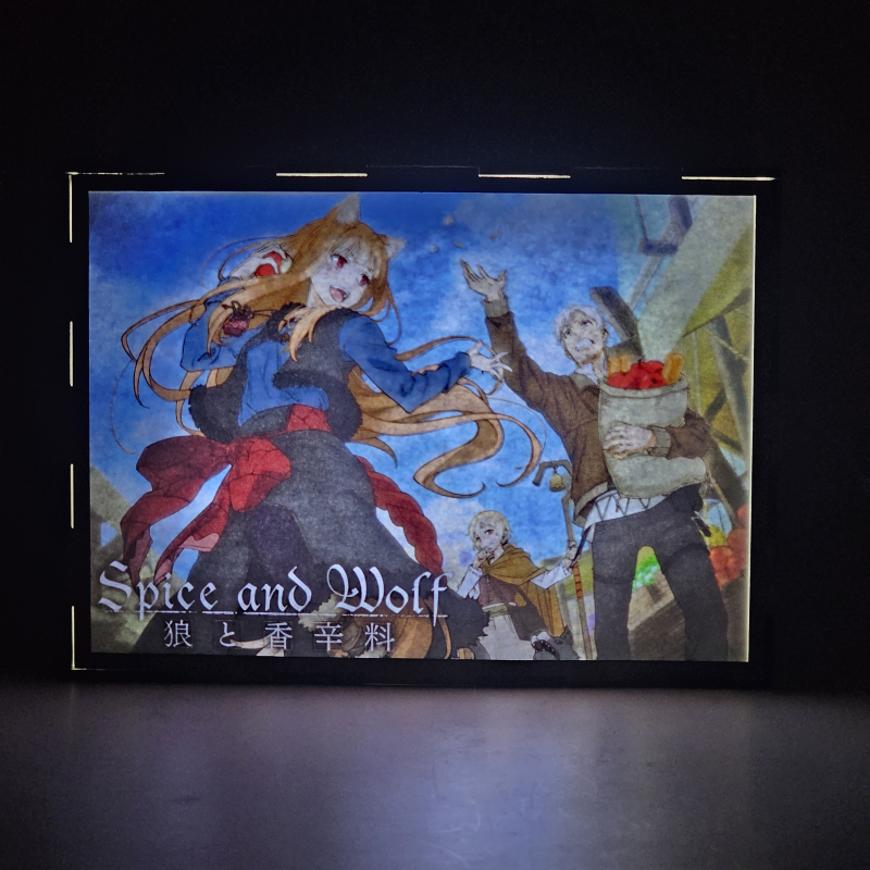 Lámpara ánime/manga  Spice and Wolf  con doble imagen del grupo Holo, Kraft Lawrence y Elsa Schieri, vista encendida, donde se revela la ilustración completa al encender la luz LED.