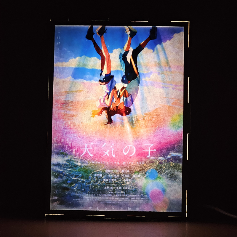 Lámpara ánime/manga  El tiempo contigo  con doble imagen de la pareja Hina Amano y Hodaka Morishima, vista encendida, donde se revela la ilustración completa al encender la luz LED.