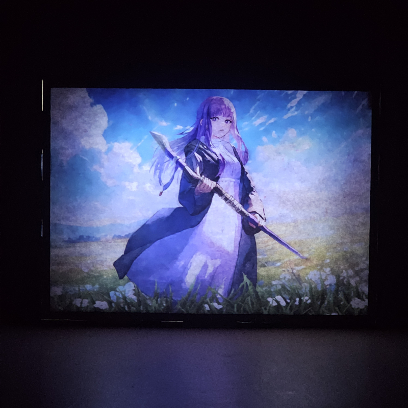 Lámpara ánime/manga  Frieren  con doble imagen del personaje Fern, vista encendida, donde se revela la ilustración completa al encender la luz LED.