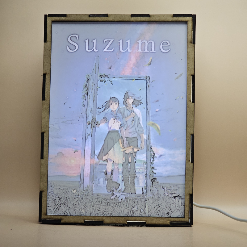 Lámpara ánime/manga  Suzume  con doble imagen del grupo Iwato Suzume, Sōta Munakata y Daijin, vista encendida, con luz ambiente, donde se revela la ilustración completa al encender la luz LED.