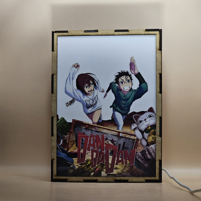 Lámpara ánime/manga  DAN DA DAN  con doble imagen de la pareja Okarun y Momo Ayase, vista encendida, con luz ambiente, donde se revela la ilustración completa al encender la luz LED.