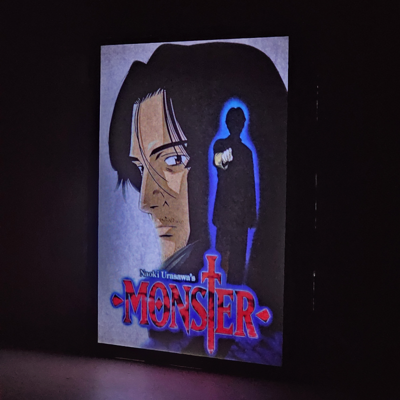 Lámpara ánime/manga  Monster  con doble imagen de la pareja Kenzo Tenma y Johan Liebert, vista encendida, donde se revela la ilustración completa al encender la luz LED.