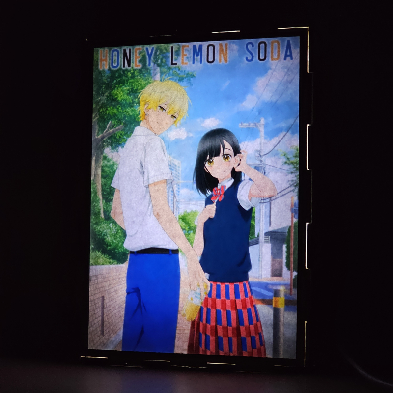 Lámpara ánime/manga  Honey Lemon Soda  con doble imagen de la pareja Kai Miura y Uka Ishimori, vista encendida, donde se revela la ilustración completa al encender la luz LED.