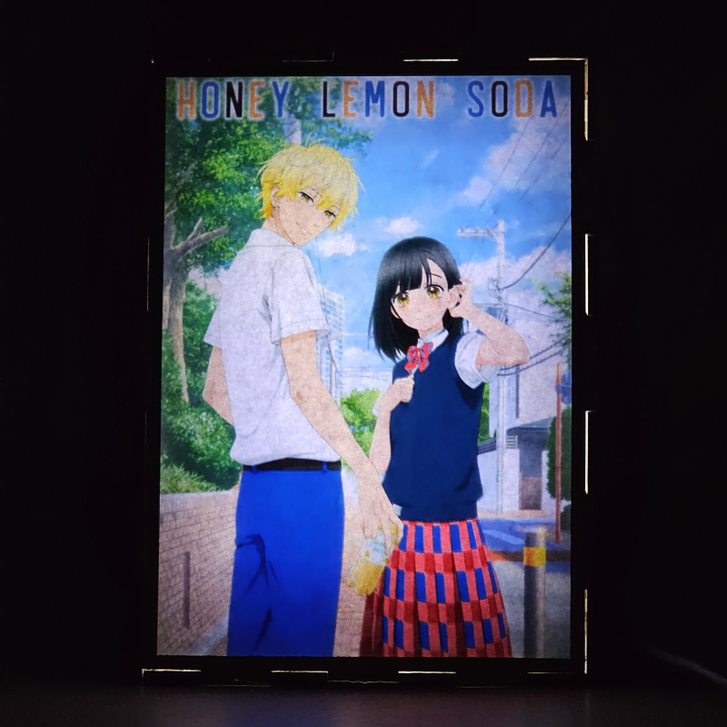 Lámpara ánime/manga  Honey Lemon Soda  con doble imagen de la pareja Kai Miura y Uka Ishimori, vista encendida, donde se revela la ilustración completa al encender la luz LED.