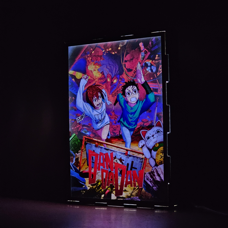Lámpara ánime/manga  DAN DA DAN  con doble imagen de la pareja Okarun y Momo Ayase, vista encendida, donde se revela la ilustración completa al encender la luz LED.
