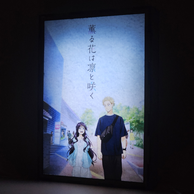 Lámpara ánime/manga  Kaoru Hana wa Rin to Saku  con doble imagen de la pareja Kaoruko Waguri y Rintaro Tsumugi, vista encendida, donde se revela la ilustración completa al encender la luz LED.