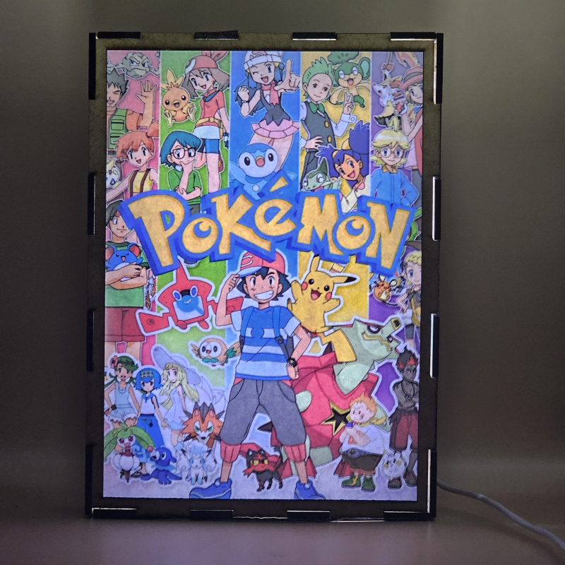 Lámpara ánime/manga  Pokémon  con doble imagen del grupo Ash Ketchum, Pikachu, Misty, Brock, Maya, Aura, Lem, Serena, Iris y Millo, vista encendida, con luz ambiente, donde se revela la ilustración completa al encender la luz LED.