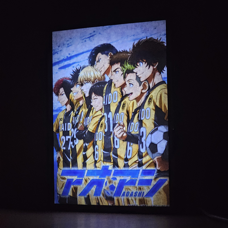 Lámpara ánime/manga  Aoashi  con doble imagen del grupo Ashito Aoi, Eisaku Ôtomo, Yuma Motoki, Keiji Togashi, Soichiro Tachibana, Kanpei Kuroda, Martis Jun Asari y Nagisa Akutsu, vista encendida, donde se revela la ilustración completa al encender la luz LED.