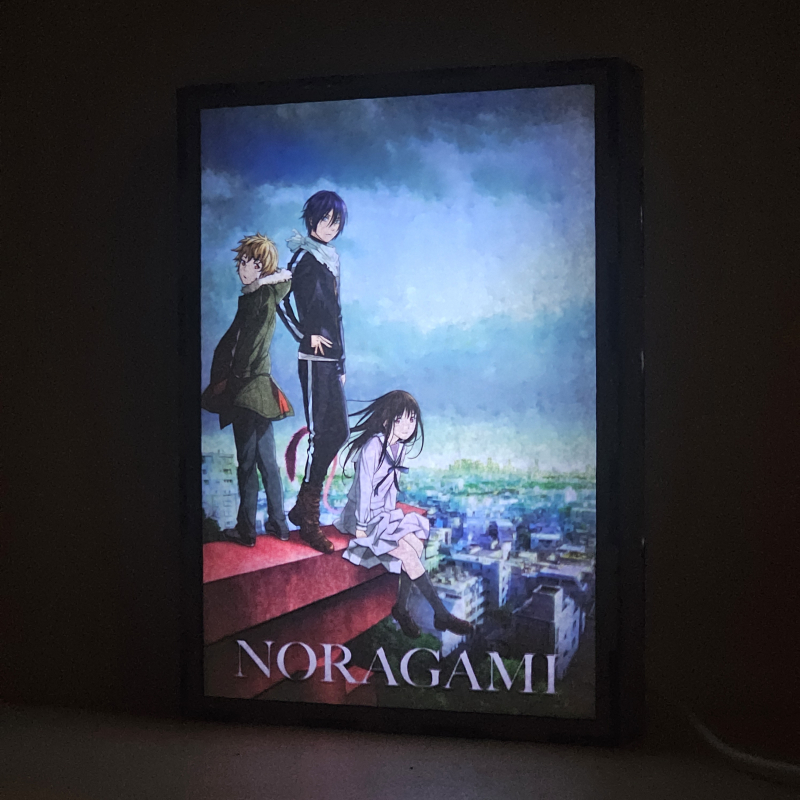 Lámpara ánime/manga  Noragami  con doble imagen del grupo Yato, Hiyori Iki y Yukine, vista encendida, donde se revela la ilustración completa al encender la luz LED.