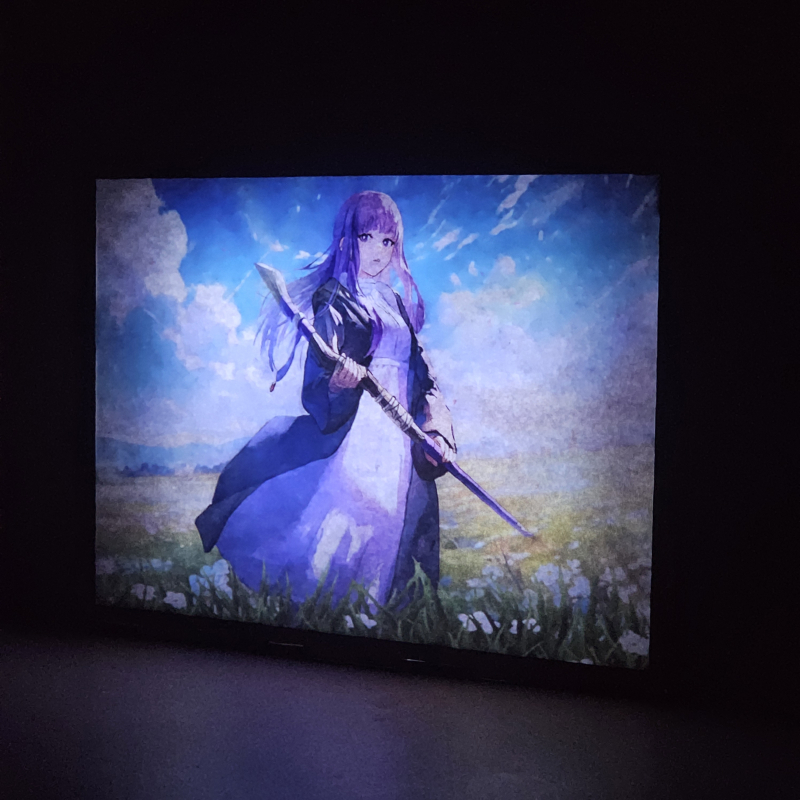 Lámpara ánime/manga  Frieren  con doble imagen del personaje Fern, vista encendida, donde se revela la ilustración completa al encender la luz LED.