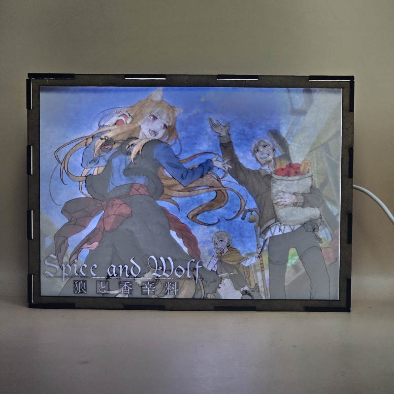 Lámpara ánime/manga  Spice and Wolf  con doble imagen del grupo Holo, Kraft Lawrence y Elsa Schieri, vista encendida, con luz ambiente, donde se revela la ilustración completa al encender la luz LED.