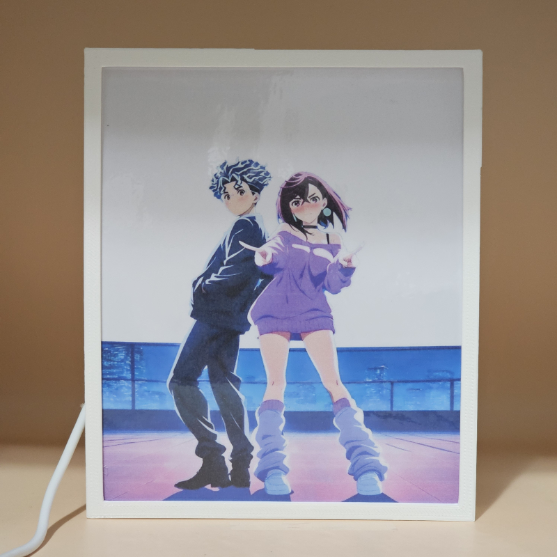 Lámpara ánime/manga  DAN DA DAN  con doble imagen de la pareja Okarun y Momo Ayase, vista apagada, se esconde la imágen de atras.