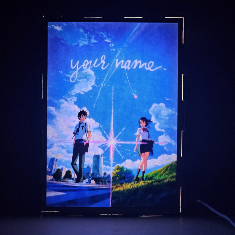 Lámpara ánime/manga  Your Name  con doble imagen de la pareja Taki Tachibana y Mitsuha Miyamizu, vista encendida, donde se revela la ilustración completa al encender la luz LED.