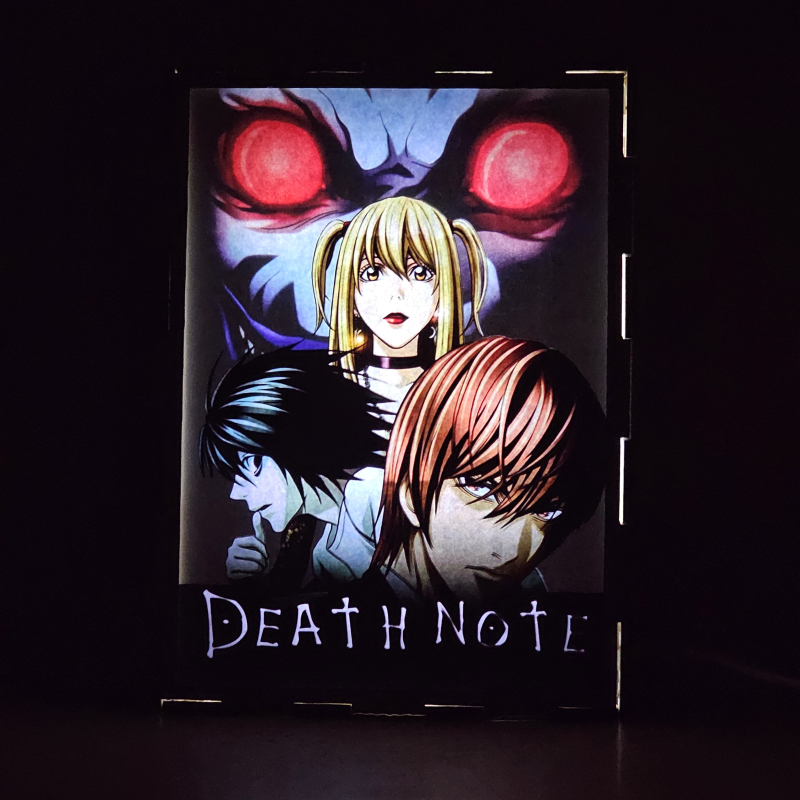 Lámpara ánime/manga  Death Note  con doble imagen del grupo Light Yagami, L, Ryuk y Misa Amane, vista encendida, donde se revela la ilustración completa al encender la luz LED.