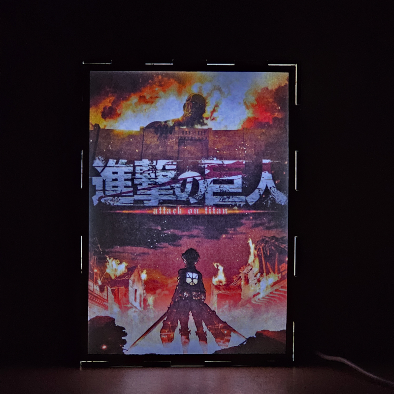 Lámpara ánime/manga  Shingeki no Kyojin  con doble imagen del grupo Eren Yeager y Bertolt Hoover, vista encendida, donde se revela la ilustración completa al encender la luz LED.
