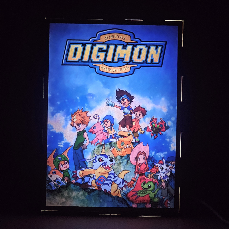 Lámpara ánime/manga  Digimon  con doble imagen del grupo Tai, Matt, Sora Takenouchi, Izzy, Mimi Tachikawa, Jou, T.K. y Kari, vista encendida, donde se revela la ilustración completa al encender la luz LED.