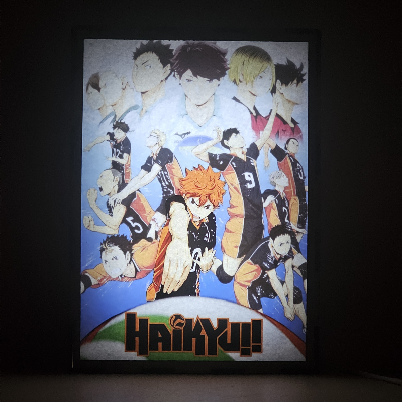 Lámpara ánime/manga  Haikyuu  con doble imagen del grupo Shoyo Hinata, Tobio Kageyama, Kei Tsukishima, Tadashi Yamaguchi, Kenma Kozume, Kuroo Tetsurō, Ryunosuke Tanaka, Yuu Nishinoya, Daichi Sawamura, Koushi Sugawara y Asahi Azumane, vista encendida, donde se revela la ilustración completa al encender la luz LED.