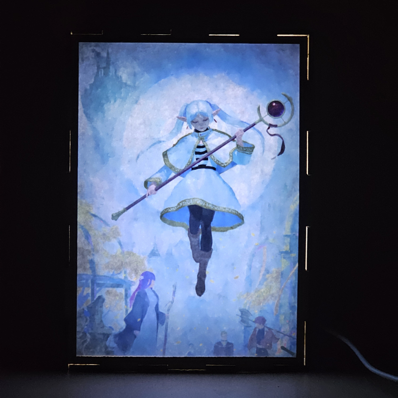 Lámpara ánime/manga  Frieren  con doble imagen del grupo Frieren, Himmel, Heiter, Fern, Eisen, Stark y Sein, vista encendida, donde se revela la ilustración completa al encender la luz LED.