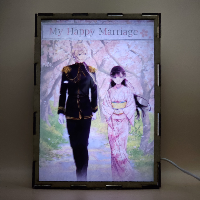 Lámpara ánime/manga  My Happy Marriage  con doble imagen de la pareja Miyo Saimori y Kiyoka Kudou, vista encendida, con luz ambiente, donde se revela la ilustración completa al encender la luz LED.