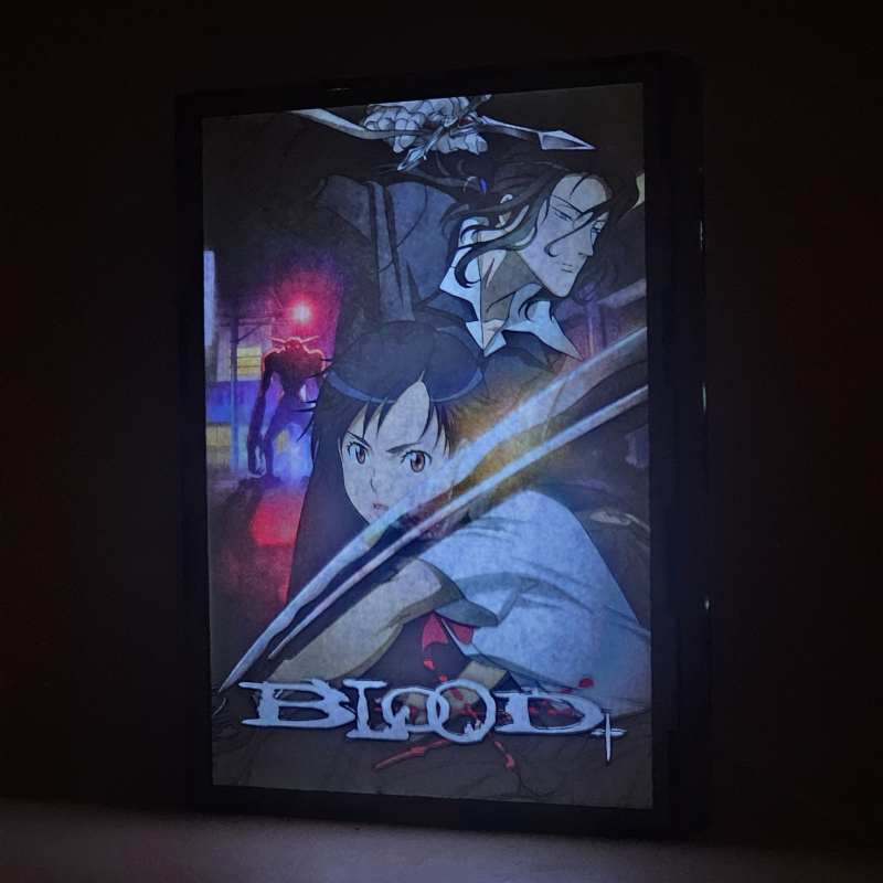 Lámpara ánime/manga  Blood+  con doble imagen de la pareja Saya Otonashi y Hagi, vista encendida, donde se revela la ilustración completa al encender la luz LED.