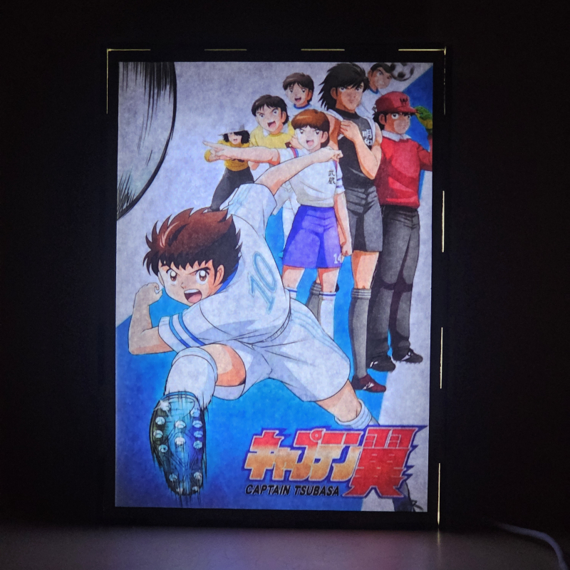 Lámpara ánime/manga  Supercampeones  con doble imagen del grupo Oliver Atom, Mark Lenders, Benji Price, Julian Ross, Tom Baker, Bruce Harper y Patty, vista encendida, donde se revela la ilustración completa al encender la luz LED.