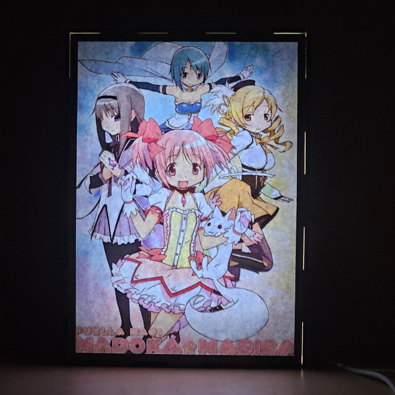 Lámpara ánime/manga  Puella Magi Madoka Magica  con doble imagen del grupo Madoka Kaname, Homura Akemi, Mami Tomoe, Sayaka Miki y Kyubey, vista encendida, donde se revela la ilustración completa al encender la luz LED.