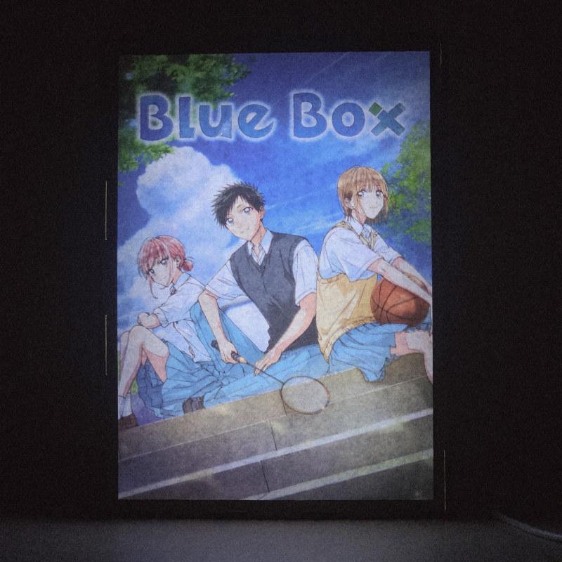 Lámpara ánime/manga  Blue Box  con doble imagen del grupo Taiki Inomata, Chinatsu Kano y Hina Chono, vista encendida, donde se revela la ilustración completa al encender la luz LED.