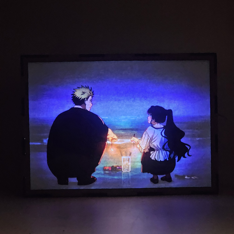 Lámpara ánime/manga  Kaoru Hana wa Rin to Saku  con doble imagen de la pareja Kaoruko Waguri y Rintaro Tsumugi, vista encendida, con luz ambiente, donde se revela la ilustración completa al encender la luz LED.
