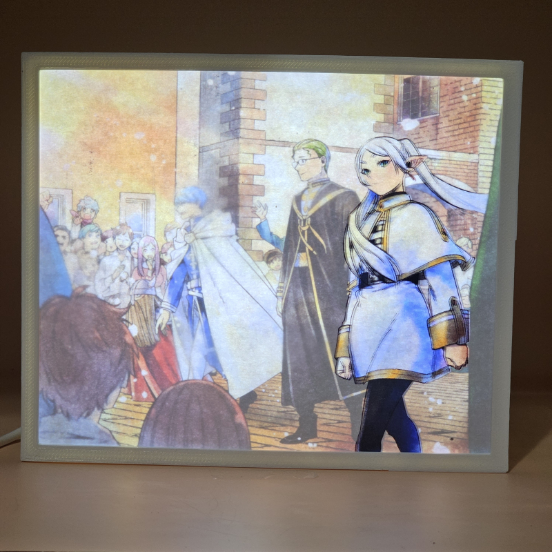 Lámpara ánime/manga  Frieren  con doble imagen del grupo Frieren, Himmel y Heiter, vista encendida, donde se revela la ilustración completa al encender la luz LED.