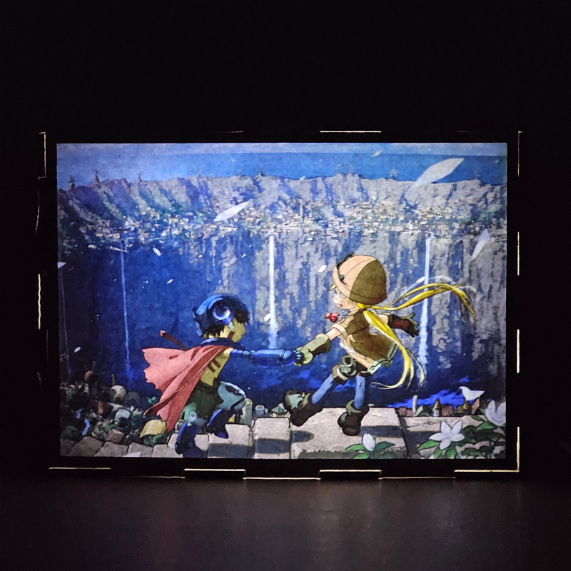 Lámpara ánime/manga  Made in Abyss  con doble imagen de la pareja Riko y Reg, vista encendida, donde se revela la ilustración completa al encender la luz LED.