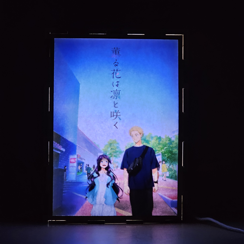 Lámpara ánime/manga  Kaoru Hana wa Rin to Saku  con doble imagen de la pareja Kaoruko Waguri y Rintaro Tsumugi, vista encendida, donde se revela la ilustración completa al encender la luz LED.