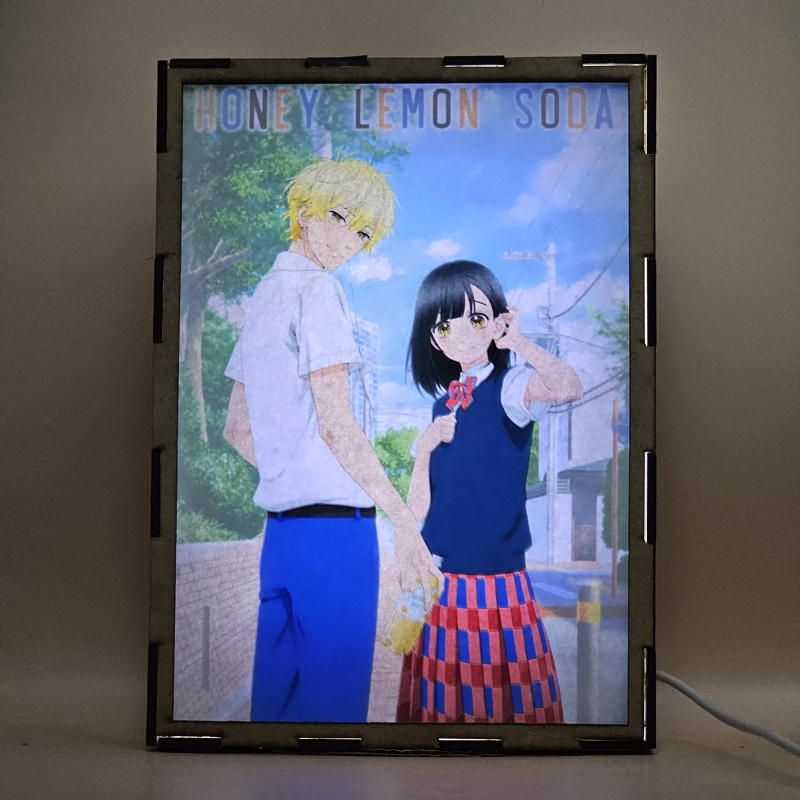 Lámpara ánime/manga  Honey Lemon Soda  con doble imagen de la pareja Kai Miura y Uka Ishimori, vista encendida, con luz ambiente, donde se revela la ilustración completa al encender la luz LED.