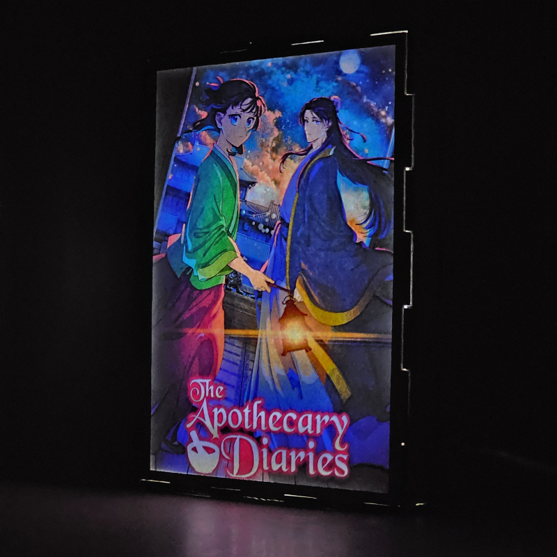 Lámpara ánime/manga  Los Diarios de la Boticaria  con doble imagen de la pareja Maomao y Jinshi, vista encendida, donde se revela la ilustración completa al encender la luz LED.