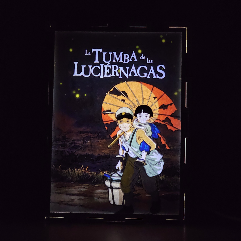 Lámpara ánime  La tumba de las luciernagas  con doble imagen de la pareja Seita y Setsuko, vista encendida, donde se revela la ilustración completa al encender la luz LED.