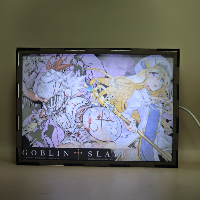 Lámpara ánime/manga  Goblin Slayer  con doble imagen de la pareja Goblin Slayer y Sacerdotisa, vista encendida, con luz ambiente, donde se revela la ilustración completa al encender la luz LED.