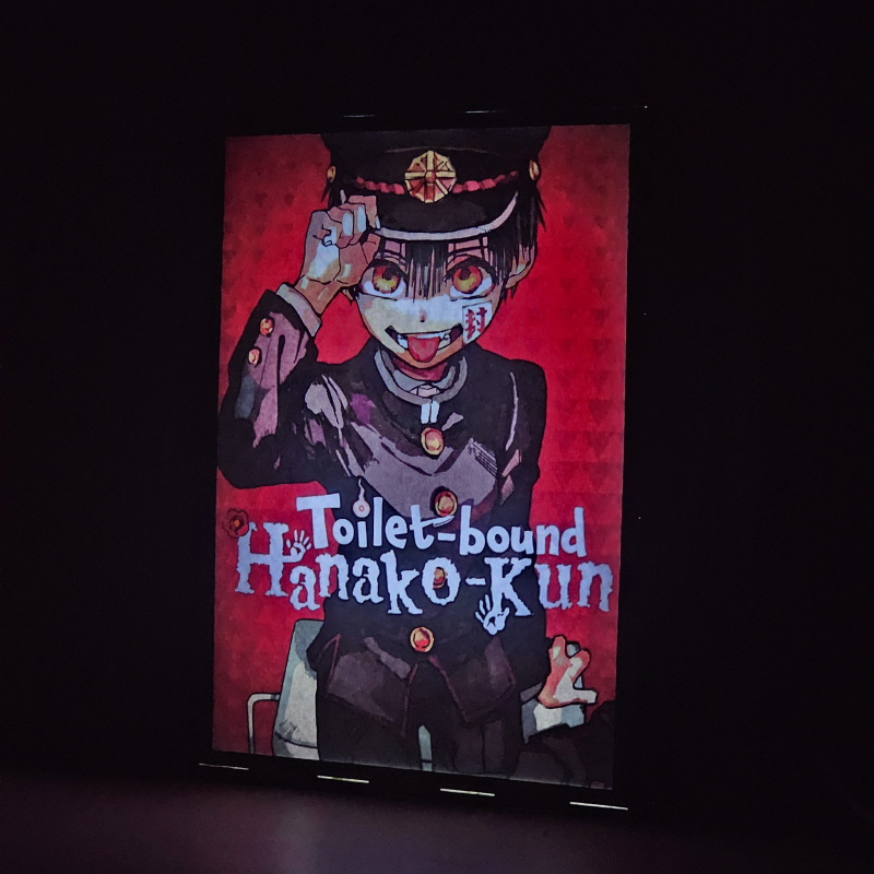 Lámpara ánime/manga  Jibaku Shōnen Hanako-kun  con doble imagen del personaje Hanako-kun, vista encendida, donde se revela la ilustración completa al encender la luz LED.