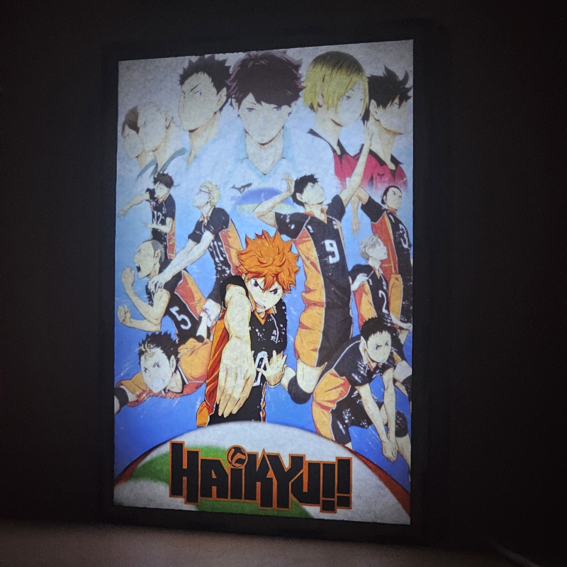 Lámpara ánime/manga  Haikyuu  con doble imagen del grupo Shoyo Hinata, Tobio Kageyama, Kei Tsukishima, Tadashi Yamaguchi, Kenma Kozume, Kuroo Tetsurō, Ryunosuke Tanaka, Yuu Nishinoya, Daichi Sawamura, Koushi Sugawara y Asahi Azumane, vista encendida, donde se revela la ilustración completa al encender la luz LED.