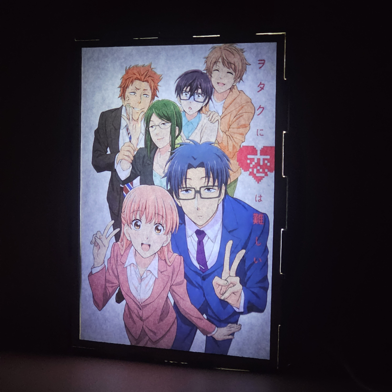 Lámpara ánime/manga  Wotakoi: El amor es difícil para los otakus  con doble imagen del grupo Hirotaka Nifuji, Hanako Koyanagi, Tarō Kabakura, Narumi Momose, Naoya Nifuji y Kō Sakuragi, vista encendida, donde se revela la ilustración completa al encender la luz LED.