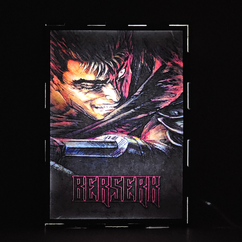 Lámpara ánime/manga  Berserk  con doble imagen del personaje Guts, vista encendida, donde se revela la ilustración completa al encender la luz LED.